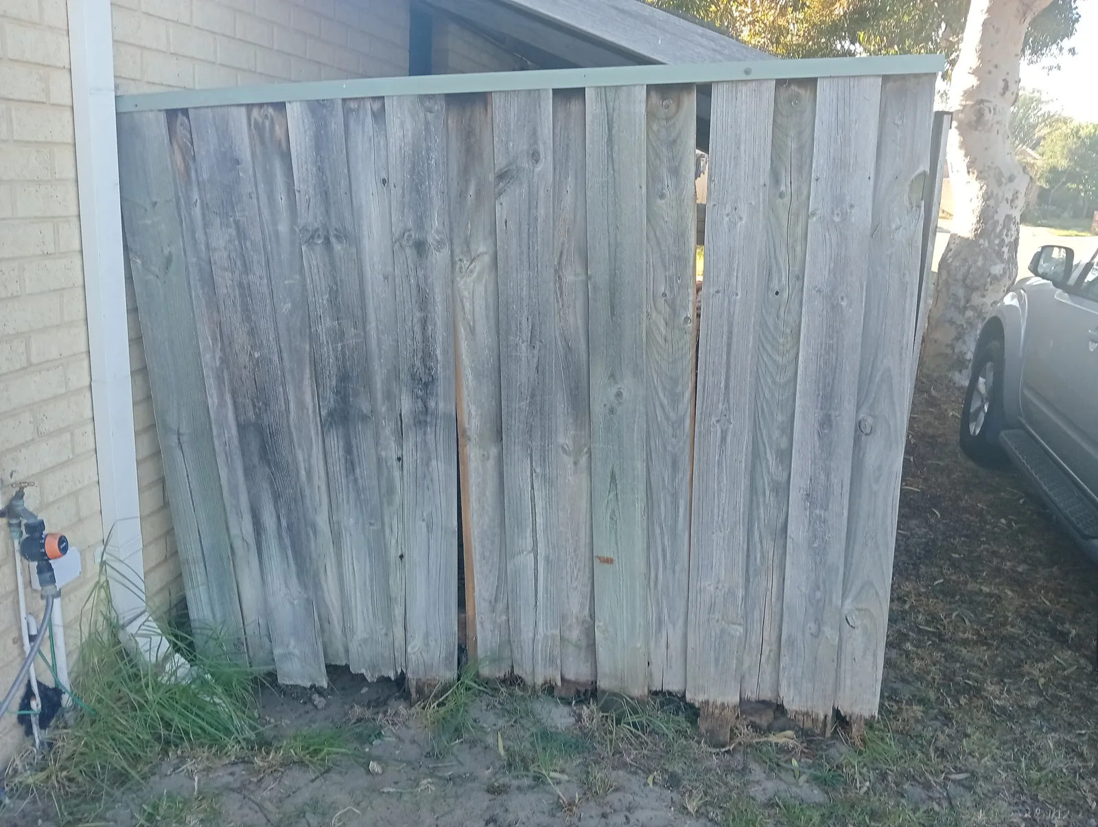 Weathered timber fence before repairs